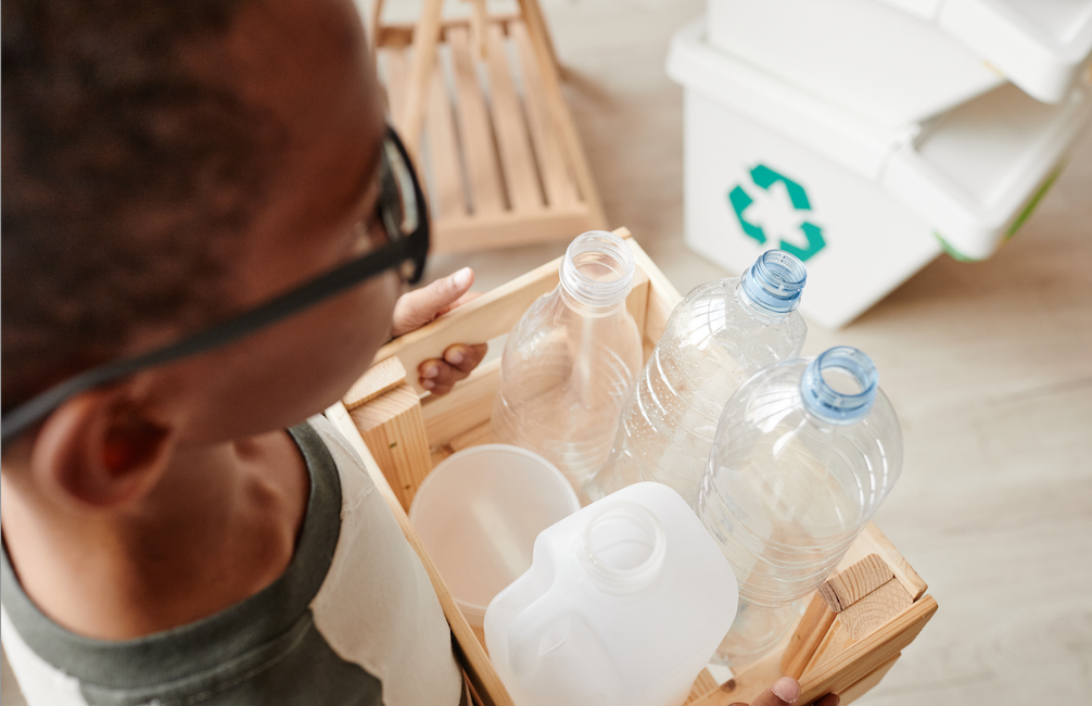 menino reciclando garrafas de plástico em casa